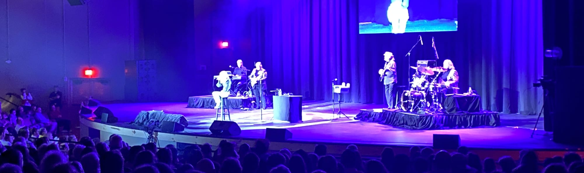 signer on stage in chair washed out by the lights Fort Collins